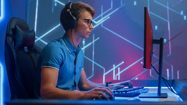 A man sits at a computer with a monitor that says'esports'on it