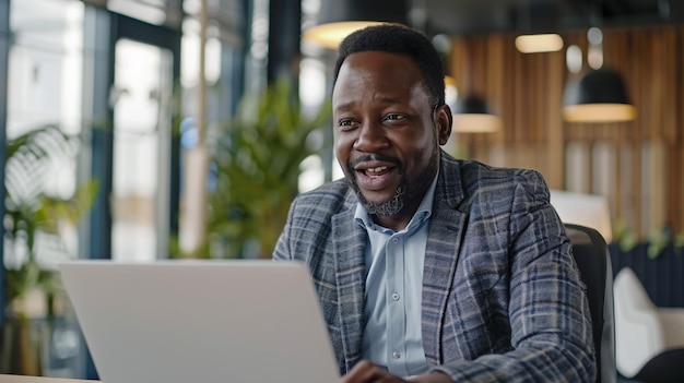 a man sits with a laptop and looks at the camera