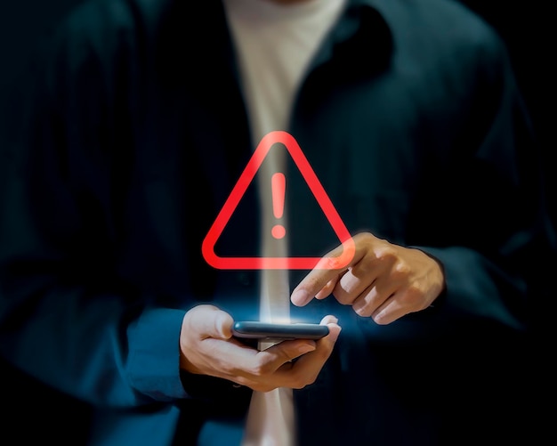 A person using a phone with a warning sign on the screen