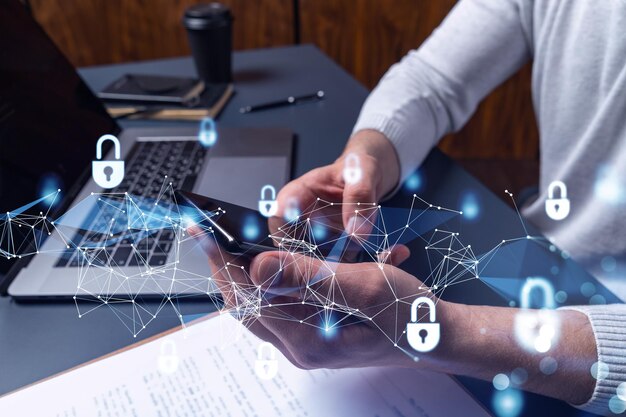 A programmer is browsing the Internet in smart phone to protect a cyber security from hacker attacks and save clients confidential data Padlock Hologram icons over the typing hands