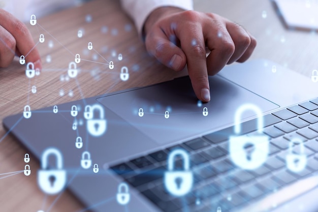A programmer is typing a code on computer to protect a cyber security from hacker attacks and save clients confidential data Padlock Hologram icons over the typing hands Formal wear