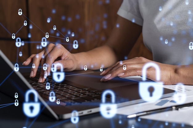 A woman programmer is typing a code on computer to protect a cyber security from hacker attacks and save clients confidential data Padlock Hologram icons over the typing hands Casual wear