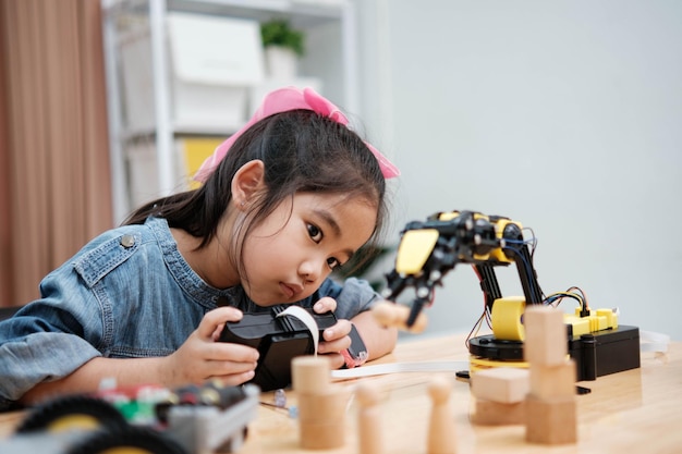 A young girl is playing with a remote control a robot