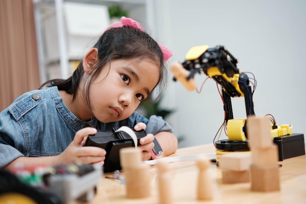 A young girl is playing with a remote control a robot