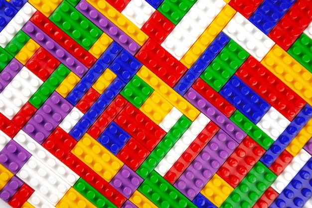Abstract background texture of colored constructor blocks Background of colorful plastic part of constructor Pile of colored toy bricks
