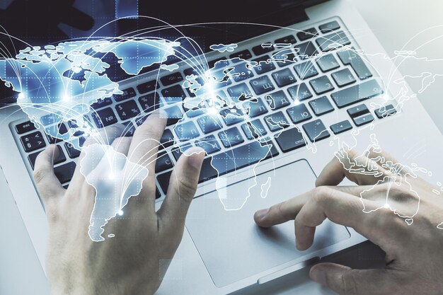 Abstrakt grafisk digitalt verdenskort med forbindelser og hænder, der skriver på computertastatur på baggrund af globaliseringskoncept Multiexponering