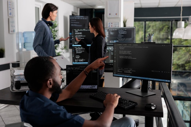 African american web developer in wheelchair looking at programming language, typing script on computer, using big data and firewall server. Engineer with physical impairment in big data office