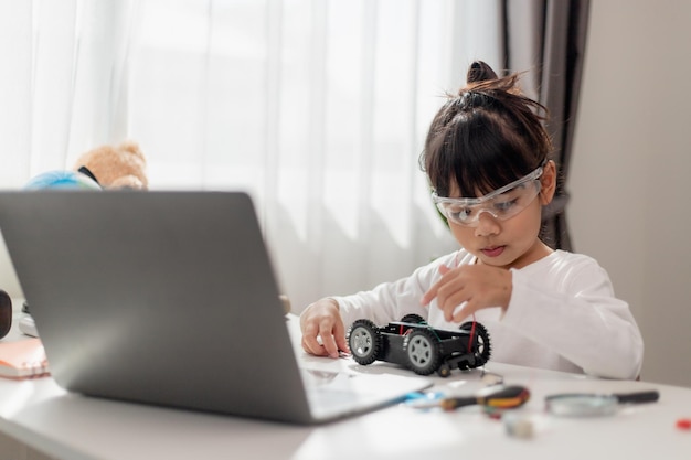 Asia students learn at home in coding robot cars and electronic board cables in STEM STEAM mathematics engineering science technology computer code in robotics for kids concept