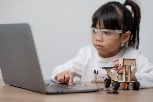 Asia students learn at home in coding robot cars and electronic board cables in STEM STEAM mathematics engineering science technology computer code in robotics for kids concept