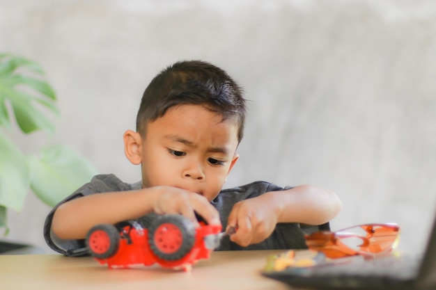 asian boy students learn at home in coding robot cars and electronic board cables in stem steam mathematics engineering science technology computer code in robotics for kids concept