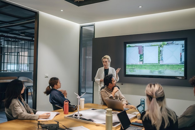 Asian business professionals discussing strategy during office presentation with colleagues