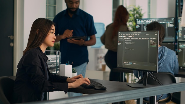 Asian programer typing big data code on computer to work on app developing program, using html script. IT system engineer writing ai algorithm and sitting at desk in it startup company.