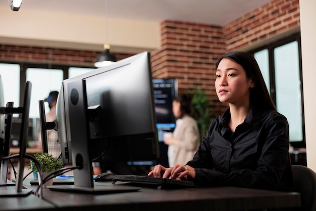 asian software developer engineering security algorithm using visual programming. cyber officer working with binary numbers for database application development through neural nodes.
