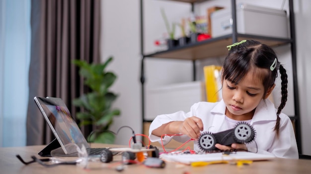Asian students learn at home by coding robot cars and electronic board cables in STEM STEAM mathematics engineering science technology computer code in robotics for kids' concepts