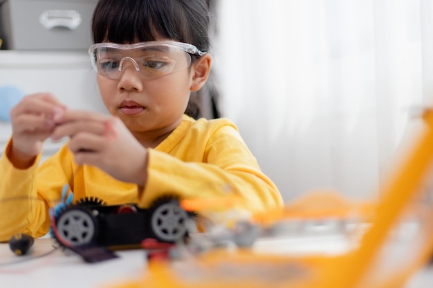 Asien studerende lærer derhjemme i kodning af robotbiler og elektroniske tavlekabler i STEM STEAM matematik ingeniørvidenskab teknologi computerkode i robotteknologi til børn koncept