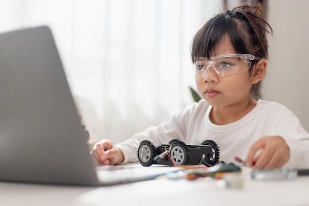 Asien studerende lærer derhjemme i kodning af robotbiler og elektroniske tavlekabler i STEM STEAM matematik ingeniørvidenskab teknologi computerkode i robotteknologi til børn koncept