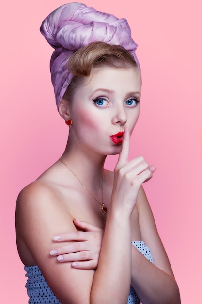 beautiful young sexy pin-up girl with surprised expression, on pink background
