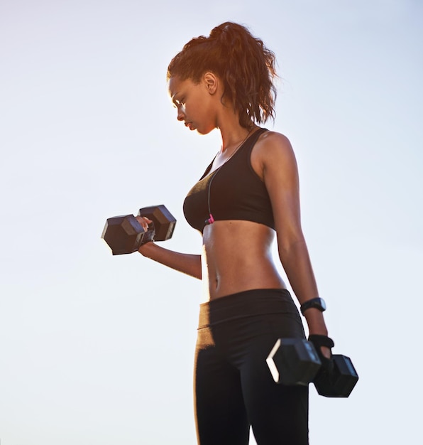 black girl blue sky and dumbbells for power training outdoor and bodybuilder for weightlifting female person equipment and strong athlete to exercise fitness and biceps for muscle development