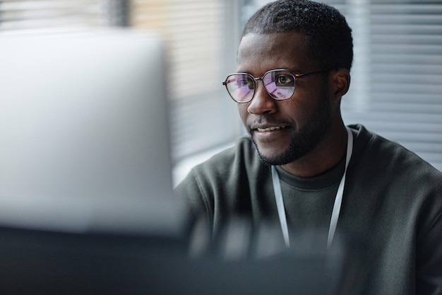 Black young man wearing glasses with screen reflection