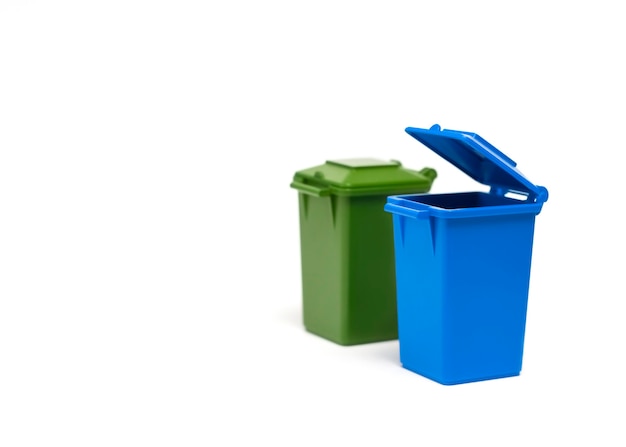 blue and green trash cans stand on a white background closeup garbage sorting concept