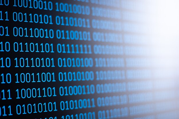 Blue binary code on screen of the computer