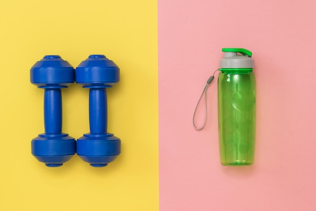 Blue dumbbells for training on a blue background. Accessories for fitness and weightlifting.