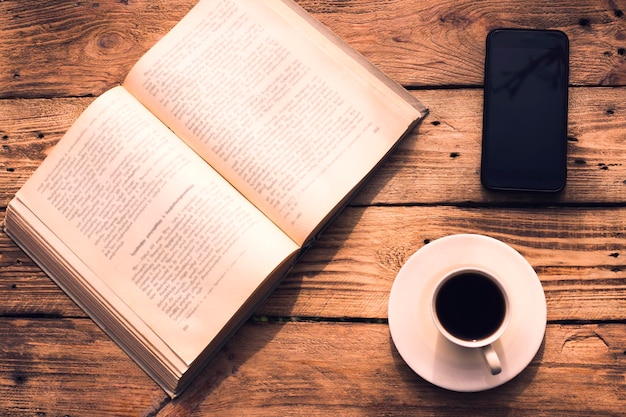 book coffee and phone in wooden background