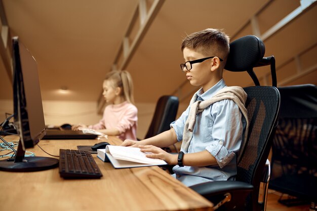 Boy and girl works on PC, little bloggers