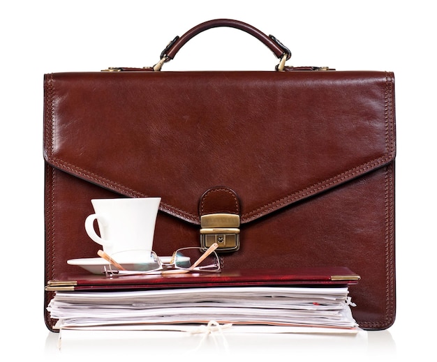 Brown leather briefcase with office accessories isolated on white background