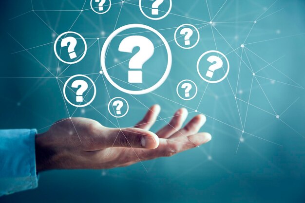 Businessman on blurred background holding hand drawn question marks
