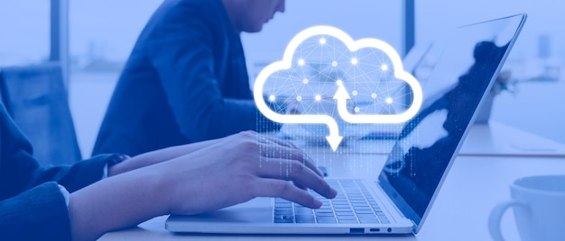businessman working at cloud data icon a man sitting on a wooden table and using a contemporary laptop by the window concept of closeup of a hand printed on a laptop