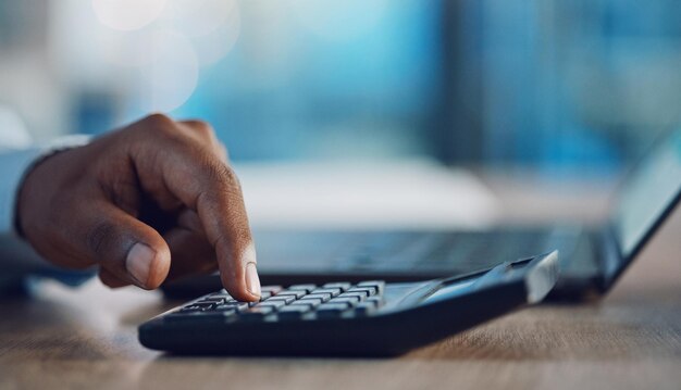 Calculator laptop and hands of business person in office for finance profit growth and accounting at desk Corporate accountant and closeup of worker with stationery for financial report or review