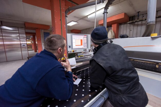 carpenters calculating and programming a cnc wood working machine