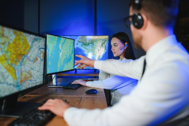 center of dispatching maintenance portrait of cheerful woman and man working via headset microphone while sitting on navigation controller board