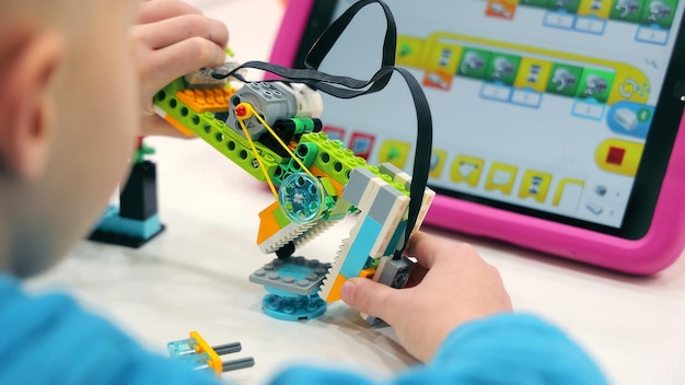 Child building robotics project with tablet a young child assembling a colorful robotics kit with a
