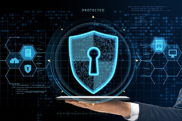 Close up of businessman hand holding tablet with abstract glowing keyhole shield interface on blurry background Protection safety and technology concept Double exposure