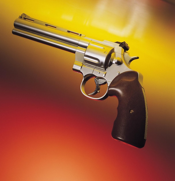 Close-up of gun against colored background