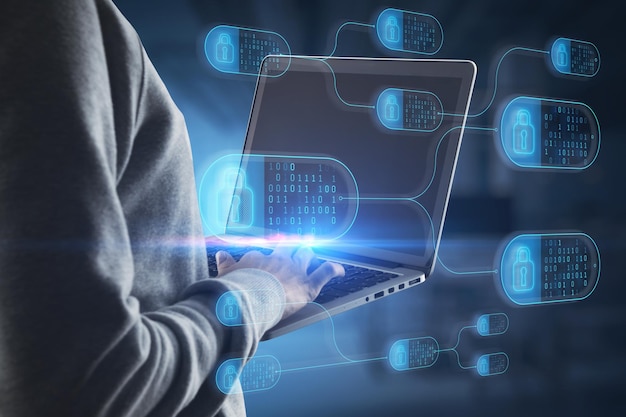 Close up of hacker hand using laptop with abstract big data and security nodes hologram on blurry office interior background Technology hacking web safety and programming concept Double exposure