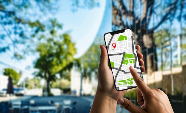 Close-up of hand holding smart phone against tree