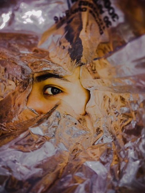 Close-up of human eye seen through foil