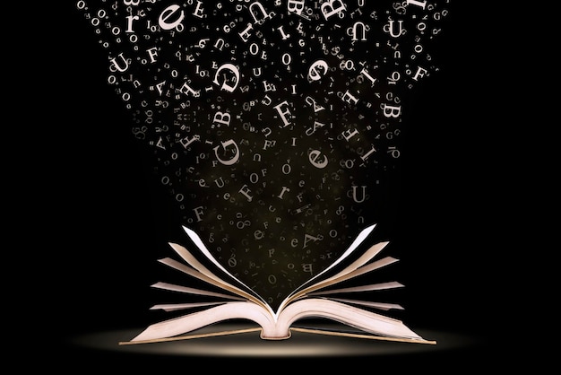 Close-up of letters over book against black background