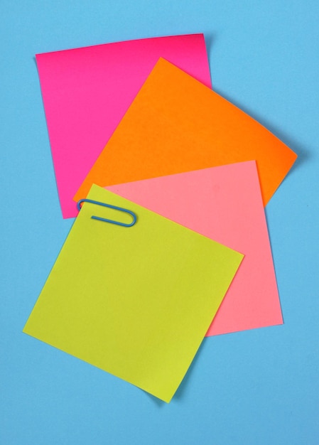 Close-up of multi colored adhesive notes against blue background