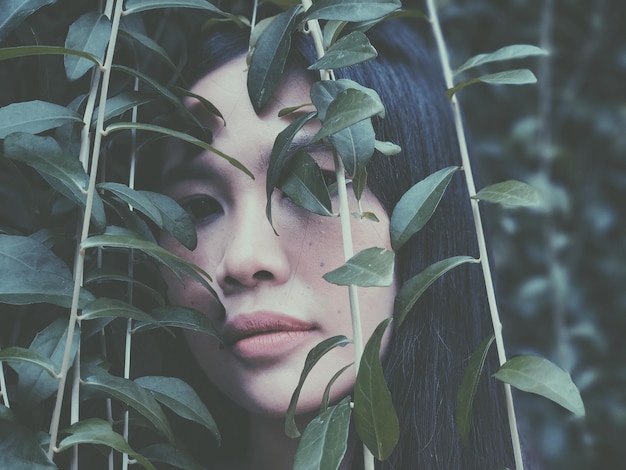 close-up of young woman with plants