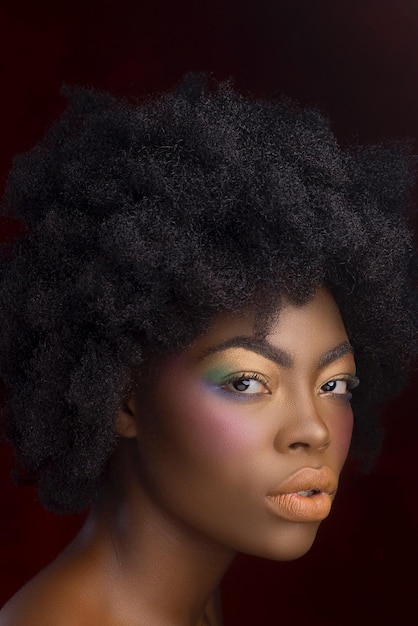 close-up portrait of young woman against black background