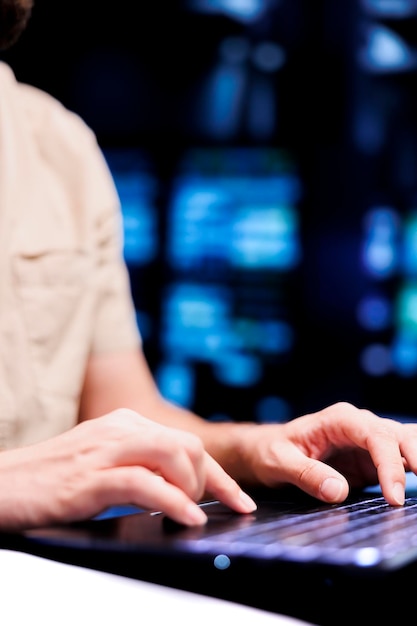 Close up shot of repairman dealing with server room system failures, using laptop to order supercomputers with high availability features to minimize downtime and prevent crashes
