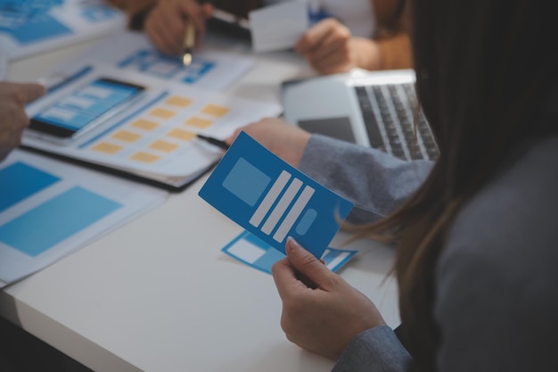 Close up ux developer and ui designer use augmented reality brainstorming about mobile app interface wireframe design on desk at modern officeCreative digital development agency