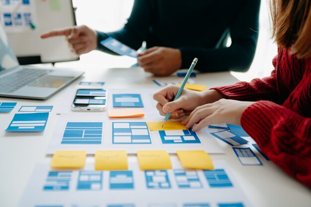 Close up view of UI developer team brainstorming on their project with laptop smartphone and digital tablet Creative digital development agency