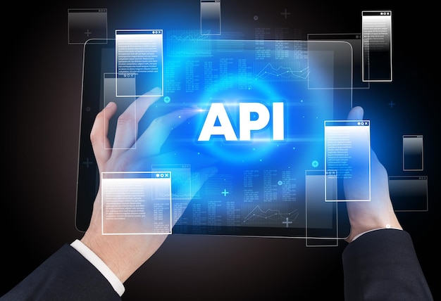Closeup of a hand holding tablet with API abbreviation modern technology concept