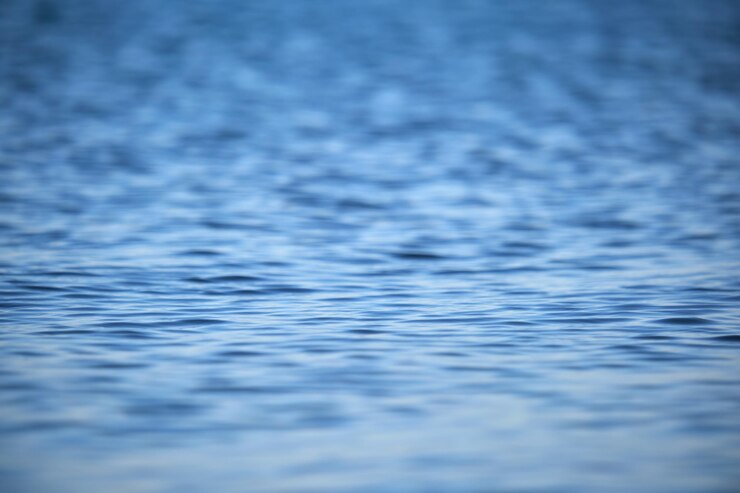 Bild closeup seascape surface of blue sea water with small ripple waves.