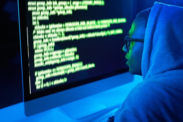 Code man or hacker with pc or screen for cybercrime malware or phishing for stealing online data Programmer dark or software update on computer with hacking expert for theft on website in night